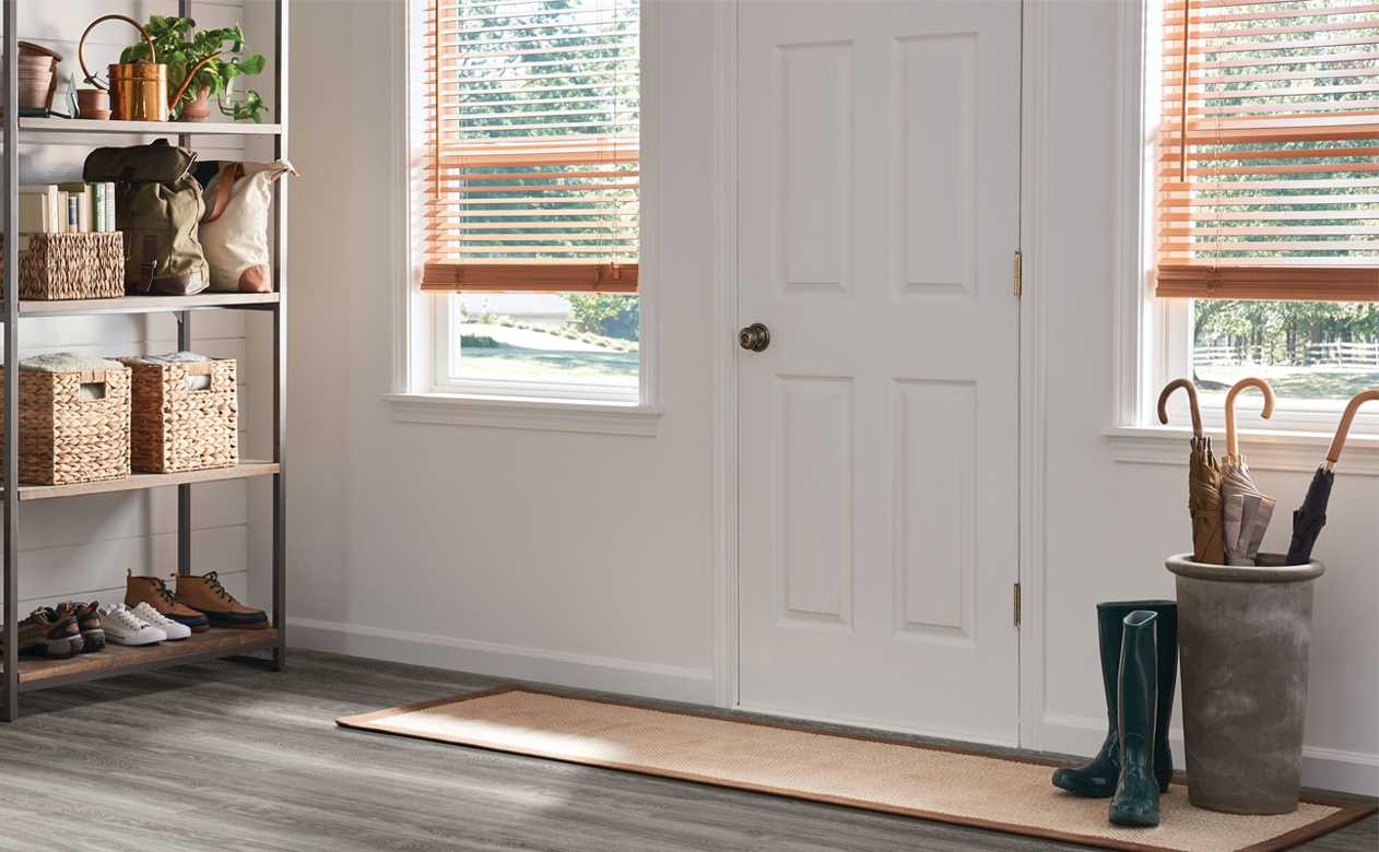 light wood-look blinds in entry way next to front door with wood-look vinyl floors